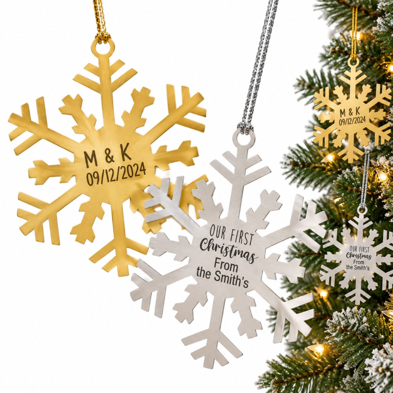Personalized gold and silver snowflake ornaments next to a Christmas tree