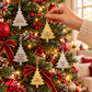 Engraved family name tree ornaments in gold and silver hanging on a decorated Christmas tree