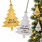 Personalized gold and silver Christmas tree ornaments next to a Christmas tree