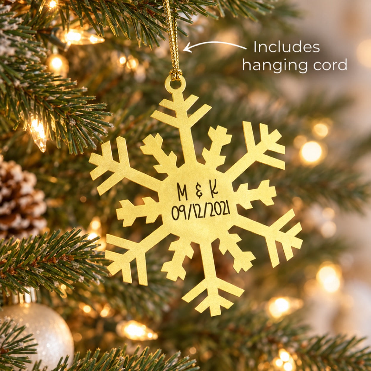 Gold snowflake ornament engraved with initials and date, hanging cord included