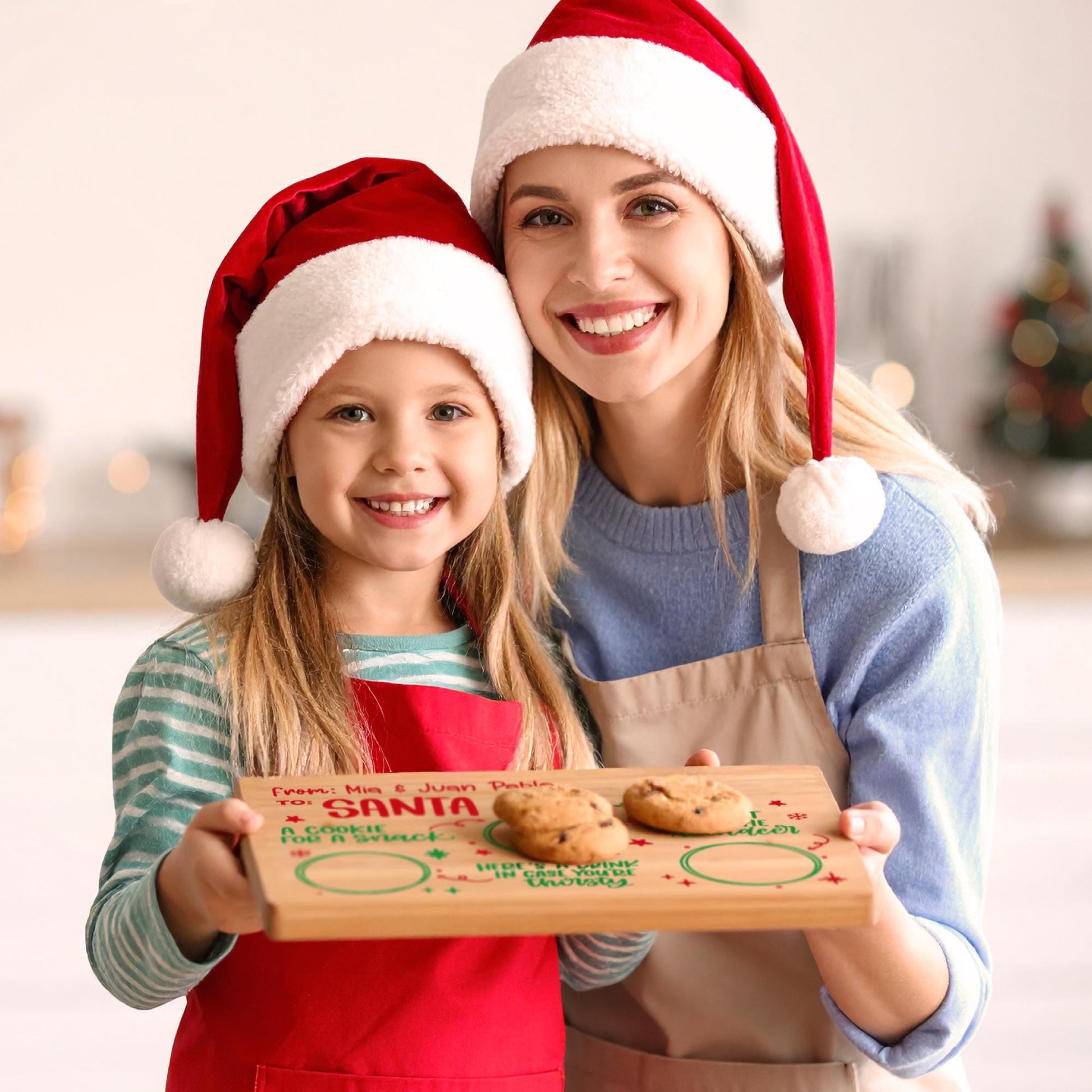 Mom and daughter holding a personalized Christmas Eve cookie board for Santa